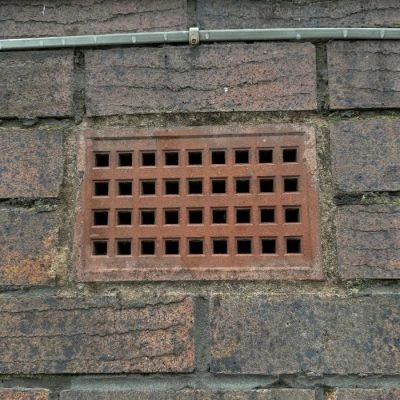 Red clay air brick installed in brick wall providing ventilation to help reduce moisture build-up in buildings